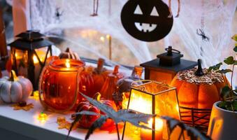 festlich Dekor von das Haus auf das Fensterbrett zum Halloween - - Kürbisse, Jack Ö Laternen, Schädel, Spinnweben, Spinnen, Skelette, Kerzen und ein Girlande - - ein gemütlich und furchtbar Stimmung foto