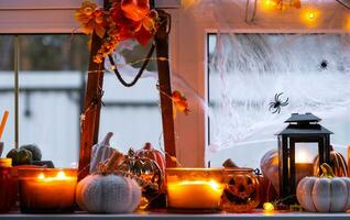 festlich Dekor von das Haus auf das Fensterbrett zum Halloween - - Kürbisse, Jack Ö Laternen, Schädel, Spinnweben, Spinnen, Skelette, Kerzen und ein Girlande - - ein gemütlich und furchtbar Stimmung foto