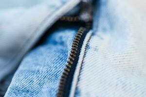 Mode Blau Licht Jeans mit Reißverschluss, Nahansicht. stilvoll Denim Stoff Textil- foto