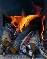 traditionell Holz Feuer Ofen Innerhalb heiß. Feuer und Brennholz Nahaufnahme. foto