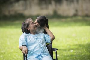 ältere Großmutter im Rollstuhl mit Enkelin im Krankenhaus foto