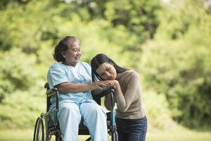 Enkelin im Gespräch mit ihrer Großmutter im Rollstuhl sitzend foto