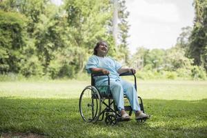 einsame ältere Frau sitzt im Rollstuhl im Garten im Krankenhaus foto