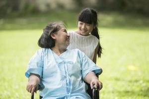 ältere Großmutter im Rollstuhl mit Enkelin im Krankenhaus foto
