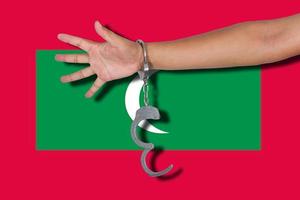Handschellen mit Hand auf Malediven-Flagge