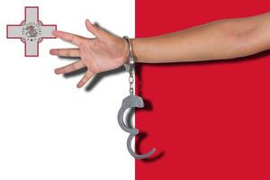 Handschellen mit Hand auf Malta-Flagge foto