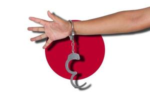 Handschellen mit Hand auf Japan-Flagge foto