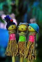 drei Kinder- Spielzeug Puppen gemacht von Holz und Stroh auf ein verschwommen Hintergrund foto