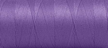 Textur von Fäden im ein Spule von lila Farbe auf ein Weiß Hintergrund foto
