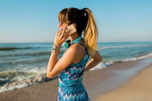 schließen oben Porträt von ziemlich Frau mit Clever Telefon auf sonnig Strand, genießen Feiertage. ziemlich Mädchen reden durch Handy, Mobiltelefon Telefon, verwenden wandernd Anrufe auf Urlaub. suchen auf Strand. foto