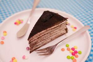 Stück von hausgemacht Schokolade Crepes Kuchen auf ein Weiß Teller foto