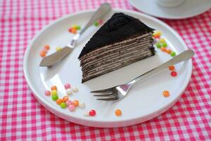 Stück von hausgemacht Schokolade Crepes Kuchen auf ein Weiß Teller foto