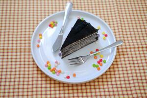 Stück von hausgemacht Schokolade Crepes Kuchen auf ein Weiß Teller foto