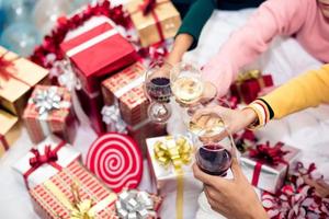Hände von Leuten, die zu Hause eine Neujahrsparty mit Weintrinken feiern foto