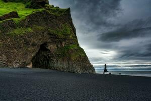 halsanefshellir Höhle mit reynisdrangar natürlich Felsen Formation auf reynisfjara schwarz Sand Strand im düster Tag beim Island foto