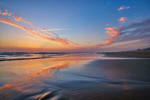 atlantisch Ozean Sonnenuntergang mit wogend Wellen beim fonte da telha Strand, Portugal foto