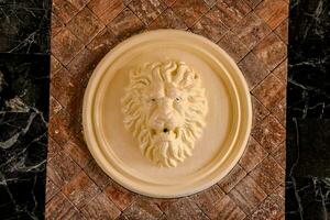 ein Löwe Kopf ist auf ein Mauer im ein Zimmer foto