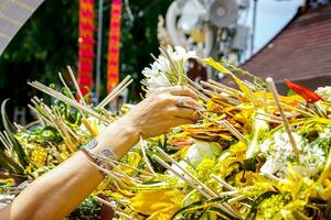 Nahansicht Hand von Menschen stellen ein duftend Blumen mit Weihrauch auf Haufen von Blumen im das thailändisch Lanna widmen ein Strauß von Blumen zu Anbetung das Buddha Tradition. foto