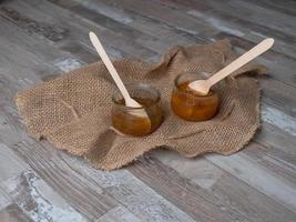 Marmelade in einem Glas mit Holzlöffel im Inneren, ökologisches Lebensmittelkonzept foto