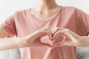 Frau macht Hände in Herzform, Liebe, Herzkrankenversicherung foto
