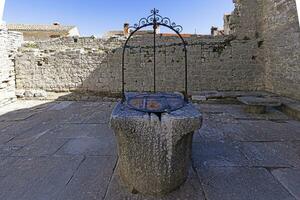 Bild von ein historisch Stein Brunnen im ein mittelalterlich Stadt, Dorf foto