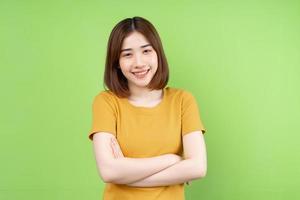 junge Asiatin posiert auf grünem Hintergrund