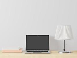 ein Arbeitszimmer mit einem Laptop mit einer Lampe auf dem Tisch. foto