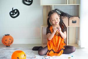 Porträt kleines Mädchen im Halloween-Kleid, das die Schokolade isst