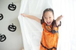 Nahaufnahmeporträt des kleinen Mädchens, das im Halloween-Raum spielt foto