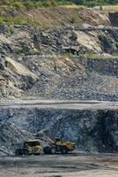 Wird geladen Stein mit ein Rad Lader auf ein Dump LKW. Stein Bergbau im das Steinbruch. foto