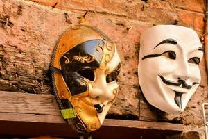zwei Masken hängend auf ein Mauer foto