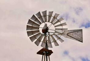 ein Windmühle mit ein Metall Pole und ein Metall Dach foto