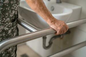 asiatisch Alten Frau geduldig verwenden Toilette Badezimmer Griff Sicherheit im Pflege- Krankenhaus, gesund stark medizinisch. foto