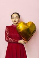 attraktiv iranisch Frau halt golden Herz geformt Luft Ballon. feiern Valentinsgrüße Tag. schön glücklich jung Naher Osten Mädchen. Urlaub Party, Liebe Tag, Jubiläum, Geburtstag Feier foto