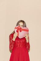 glücklich jung Mädchen hält Herz geformt Geschenkbox. Valentinsgrüße Tag, Geburtstag, Damen Tag, Jubiläum, Urlaub Feier Konzept foto