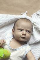 2 Monat Baby Junge lügnerisch. Nahansicht von bezaubernd süß Neugeborene Baby Junge von zwei Monate. Baby mit verdächtig Gesicht. ernst wenig Kind. emotional Entwicklung im Kinder. foto