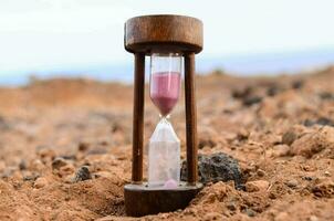 ein Sanduhr ist Sitzung auf das Boden im ein Wüste foto