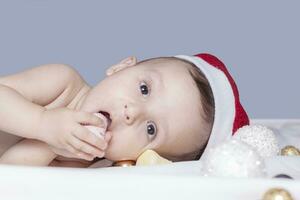 9 Monat Baby Junge mit Santa claus Hut. Weihnachten Morgen. wenig Kind spielen. foto