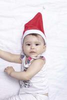 wenig Weihnachtsmann. 1 Jahr alt Baby Mädchen im Santa claus Hut. fröhlich Weihnachten. bezaubernd Naher Osten Mädchen im Santa Deckel. foto