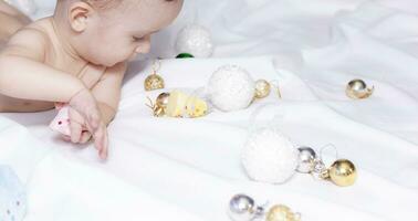 Baby Junge spielen mit Weihnachten Bälle und Spielzeuge foto