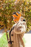 fallen Jahreszeit Konzept. schön Naher Osten Frau hält ein Gelb Herbst Blatt foto