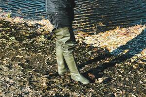 Gummi hoch Stiefel beim das Fischer zum Angeln. foto