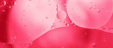 Rosa Öl Luftblasen schließen hoch. Kreise Wasser Makro. abstrakt glänzend viva Magenta Hintergrund foto