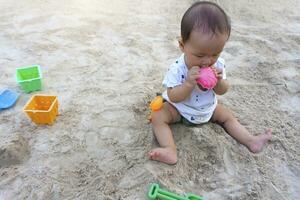 asiatisch Kleinkind Baby thailändisch Mädchen spielen mit Sand foto