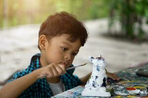 asiatisch Kinder genießen seine Gemälde mit Pinsel foto