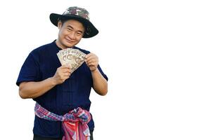 gut aussehend asiatisch Mann Bauer, trägt Hut, Blau Shirt, hält thailändisch Banknoten Geld, isoliert auf Weiß Hintergrund. Konzept, Landwirtschaft Beruf. thailändisch Bauer. profitieren, Einkommen. foto