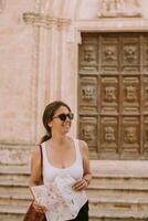 weiblich Tourist mit Stadt Karte durch das Kirche san francesco dassisi im Ostuni, Italien foto