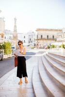 weiblich Tourist mit Stadt Karte durch das Heilige oronzo Statue im Ostuni, Italien foto