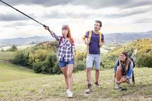 Gruppe von jung Wanderer Gehen zu das Horizont Über das Berg foto