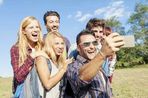 Gruppe von lächelnd freunde nehmen Selfie mit Smartphone foto